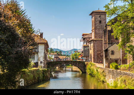 View of the river Nive on its way through the village of Saint Jean Pied de Port and in the background the Pyrenees. France. Stock Photo