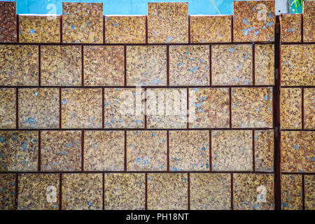 Brown ceramic tiles patterned in dirty laterite stone wall texture background. Stock Photo
