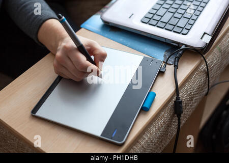 Drawing board with women hand using pad and laptop, close up Stock Photo