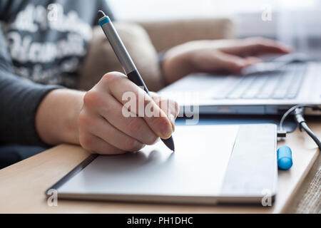 Close-up view at pen of drawing board painting on surface, woman illustrator in work Stock Photo