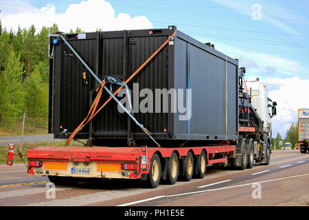 Orivesi, Finland - August 27, 2018: White semi truck hauls wide container on Noteboom trailer on highway among other trucks, rear view. Stock Photo