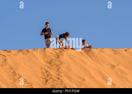 LAMPOUL DESERT, SENEGAL - APR 23, 2017: Unidentified tourist's little children stand on the top of sand dune in a Lampoul Desert, beautiful landscape  Stock Photo