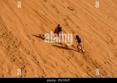 LAMPOUL DESERT, SENEGAL - APR 23, 2017: Unidentified tourist's little children climb on the top of sand dune in a Lampoul Desert, beautiful landscape  Stock Photo