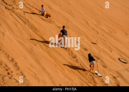 LAMPOUL DESERT, SENEGAL - APR 23, 2017: Unidentified tourist's little children climb on the top of sand dune in a Lampoul Desert, beautiful landscape  Stock Photo