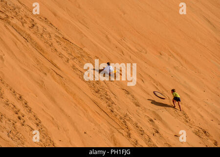 LAMPOUL DESERT, SENEGAL - APR 23, 2017: Unidentified tourist's little children climb on the top of sand dune in a Lampoul Desert, beautiful landscape  Stock Photo