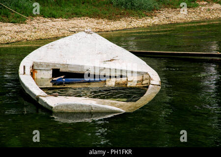 Old small fishing boat sunk in the sea. Stock Photo