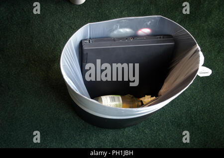 Old Laptop thrown in a waste bin at the office in the City area of London, England Stock Photo