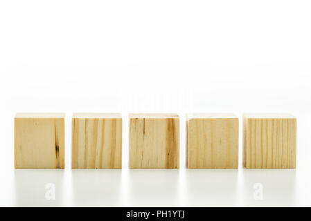 Row of five blank wooden blocks on a white background with copyspace for your text, letters or numbers. Stock Photo