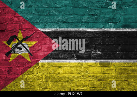 Flag of Mozambique over an old brick wall background, surface Stock Photo