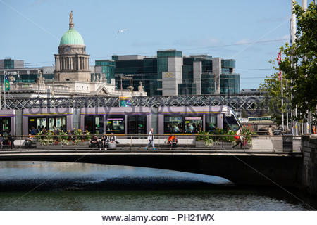 A Luas tram passes across the River Liffey in Central Dublin, Ireland Stock Photo