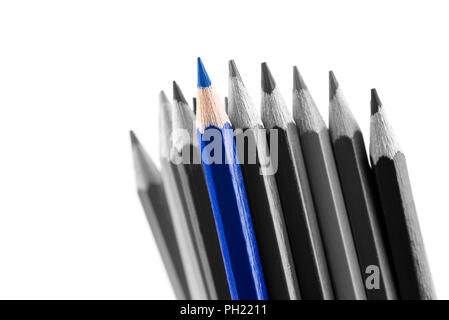 Pile of sharp colored pencils, with different hues, from black to light grey and a blue outstanding one, close-up on white background. Stock Photo