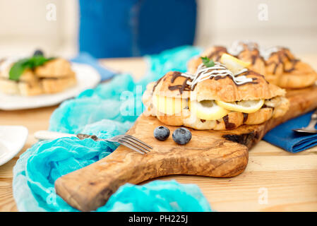 Close-up chef decorating sweet croissant on cooking table unrecognizable rear view. Stock Photo