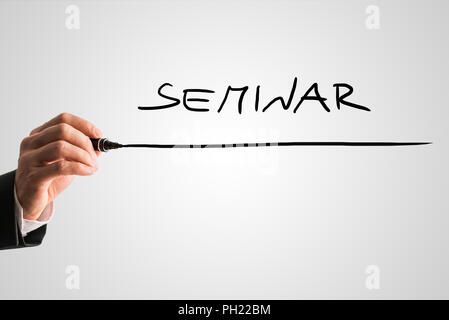 Closeup of male hand writing word Seminar on virtual screen. Conceptual of online seminar, e-business and e-learning. Stock Photo