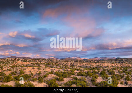 Dramatic colorful clouds at sunset over the Sangre de Cristo Mountains and desert near Santa Fe, New Mexico Stock Photo