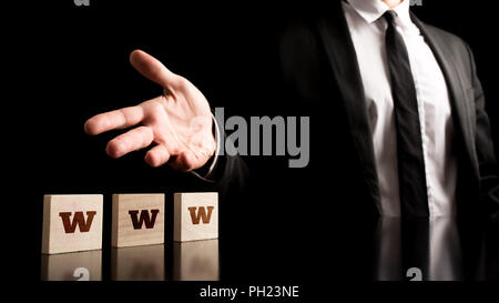 Businessman Representing Small Wooden Pieces with WWW Letters on Black Background. Stock Photo