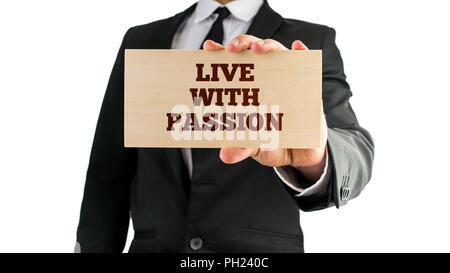 Man holding a wooden block reading Live with passion, close up of his hand in a motivational conceptual image. Stock Photo