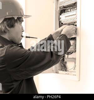 Electrician checking fuse box. Stock Photo