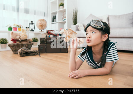 kid pouting and dreaming with her favorite toy. she has a big adventured dream. Stock Photo