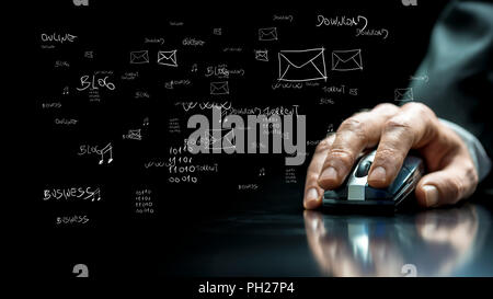Close up view of the hand of a businessman using a computer mouse on a reflective black surface with hand-drawn notations and computer icons on the da Stock Photo