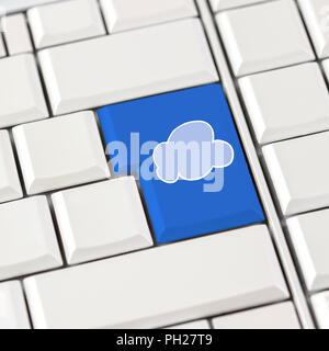 Cloud icon in blue on a white computer keyboard conceptual of cloud computing, storage, networking and global access. Stock Photo