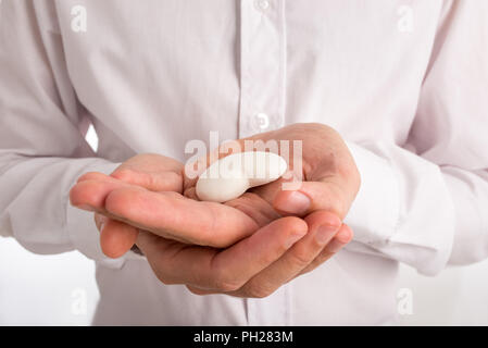 Close Up of Man Holding Small White Heart in Palm of Hands. Stock Photo