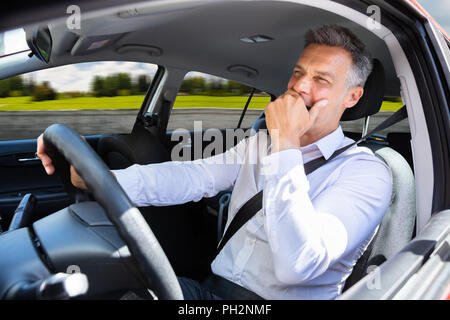 Close-up Of A Mature Man Yawning While Traveling In Car Stock Photo