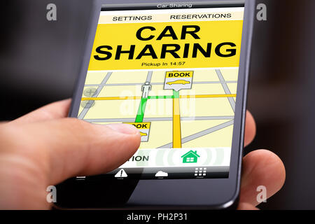 Person Using Car Sharing Application On Cell Phone Stock Photo