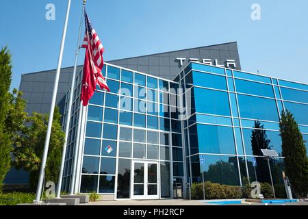 American flag flying in front of new glass building for Tesla Motors near the company's headquarters in the Silicon Valley, Fremont, California, July 28, 2018. () Stock Photo