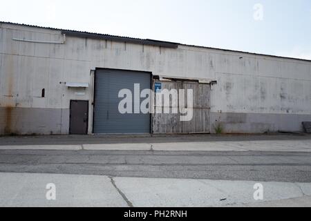Rust and peeling paint on larger hangar doors at the defunct Alameda Naval Air Station (NAS), a former US Navy base on Alameda Island, Alameda, California, August 13, 2018. () Stock Photo