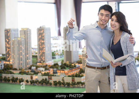 Happy young couple buying new house from sales center Stock Photo