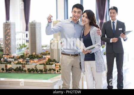 Happy young couple buying new house from sales center Stock Photo