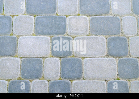 Pavement in the city. Stone tile of light and dark stone. Abstract background. Close-up. Stock Photo