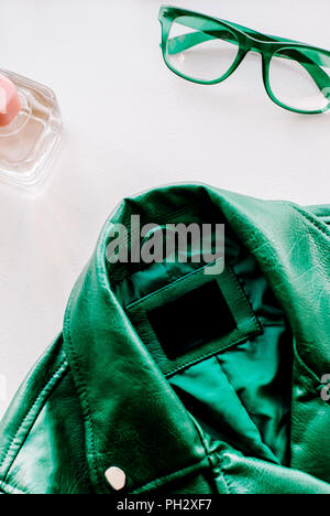 green leather jacket and green sunglasses on white background Stock Photo