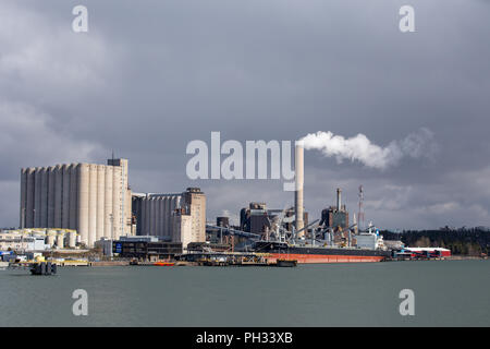 Bulk Carrier ship at Naantali harbour with Naantali Power Plant in the background Stock Photo