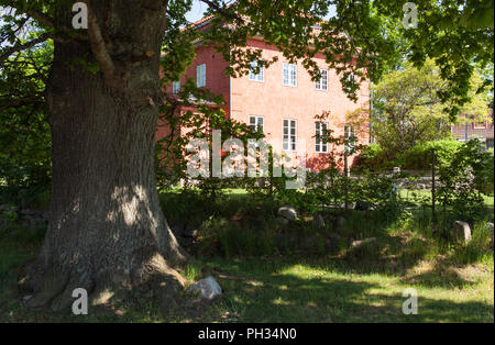 TINGSRYD, SWEDEN ON MAY 16, 2018. Outdoor view of a building partly hidden behind vegetation. Garden this side. Editorial use. Stock Photo