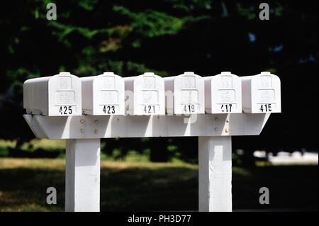 Bartlett, Illinois, USA. A series of mailboxes mounted together along a cul-de-sac surrounded by townhouses. Stock Photo