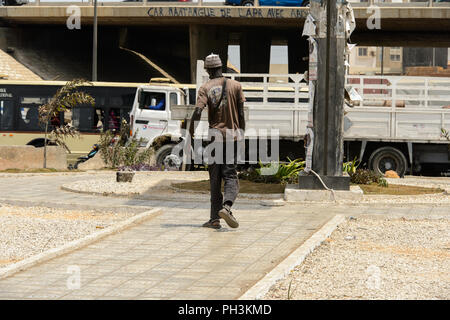 DAKAR, SENEGAL - APR 27, 2017: Unidentified Senegalese man walks in front of the truck in Dakar, the capital of Senegal Stock Photo