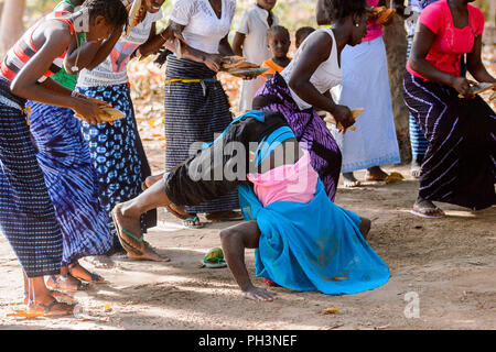 Kaguit vil., SENEGAL - APR 30, 2017: Unidentified Diola man makes somersault during a traditional dance Kumpo in a Sacred Forest near Kaguit village Stock Photo