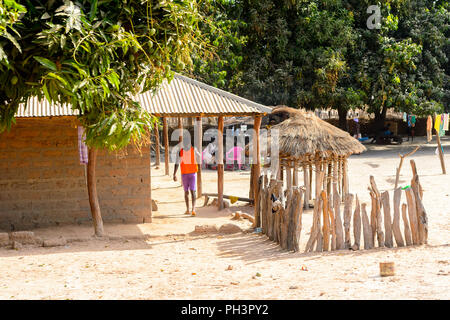 ROAD TO BISSAU, GUINEA B. - MAY 1, 2017: Unidentified local man walks under the roof in a village in Guinea Bissau. Still many people in the country l Stock Photo