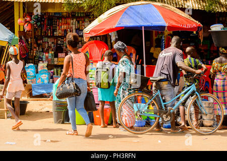 ROAD TO BISSAU, GUINEA B. - MAY 1, 2017: Unidentified local people walk at the market in a village in Guinea Bissau. Still many people in the country  Stock Photo