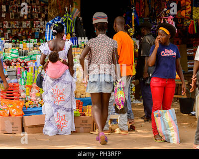 ROAD TO BISSAU, GUINEA B. - MAY 1, 2017: Unidentified local people walk at the market in a village in Guinea Bissau. Still many people in the country  Stock Photo