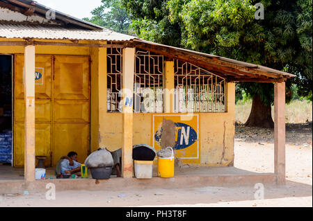 ROAD TO BISSAU, GUINEA B. - MAY 1, 2017: Unidentified local man lies near the entrance to the building in a village in Guinea Bissau. Still many peopl Stock Photo