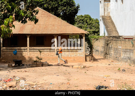 ROAD TO BISSAU, GUINEA B. - MAY 1, 2017: Unidentified local man walks with a bag in a village in Guinea Bissau. Still many people in the country live  Stock Photo