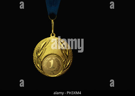 the winner's gold medal for the first place. Isolated on a black background. place for text. Stock Photo