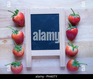 Strawberry and black board on wooden pattern background, Stock Photo