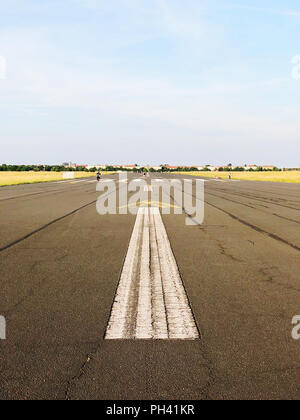 Painted arrow sign on the asphalt of the old runway at Tempelhofer Feld in Berlin, Germany in summer 2018. Stock Photo