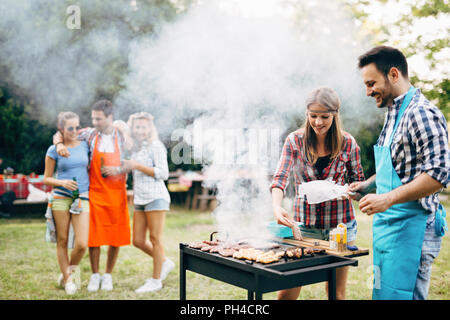 Happy students having barbecue on summer day Stock Photo