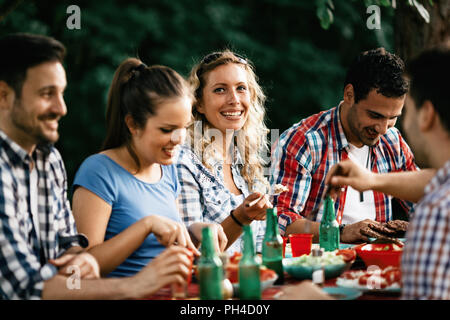 Group of happy people eating food outdoors Stock Photo