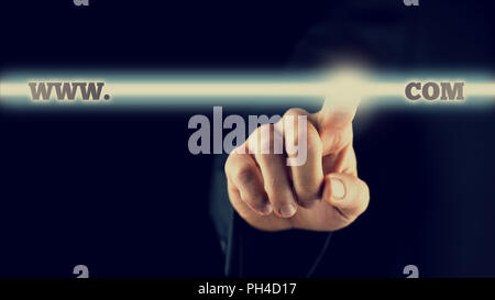 Closeup of businessman activating a www.com button on virtual screen, toned retro effect. Stock Photo