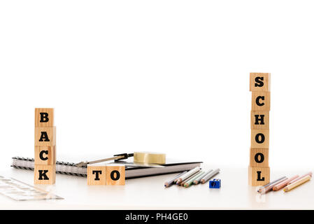 School concept with the words - Back To School - displayed on stacked wooden blocks with pencils, pencil crayons, rubber, sharpener and notebook depic Stock Photo